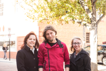 Two women and one man outside posing for a photo