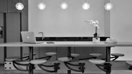 Black and white image of a kitchen with a Macbook and some decorations on a table